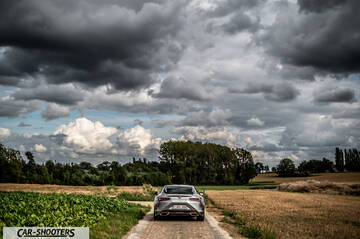 Lexus LC500h – rear view, silver on a rural road under stormy skies