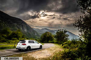 Volkswagen Golf Gti Tcr – rear three-quarter, white on a winding road against a mountain backdrop