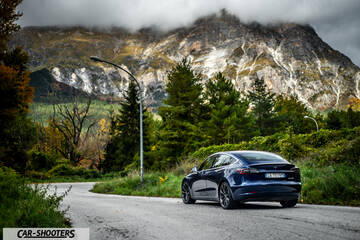 Tesla Model S Performance – rear three-quarter, dark blue against a mountain backdrop