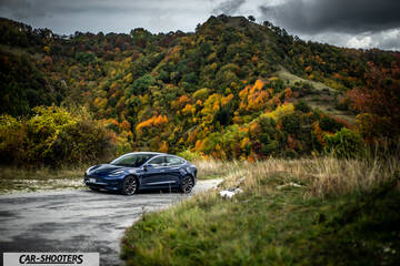 Tesla Model S Performance – front three-quarter, blue against a mountain backdrop