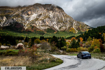 Tesla Model S Performance – rear three-quarter, dark blue against a mountain backdrop