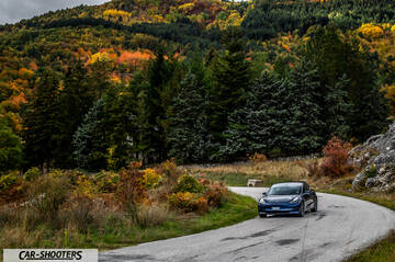 Tesla Model S Performance – front three-quarter, blue against a mountain backdrop