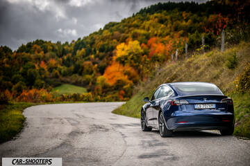 Tesla Model S Performance – rear three-quarter, blue metallic on a country road