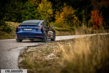 Tesla Model S Performance – rear three-quarter, blue metallic on a country road