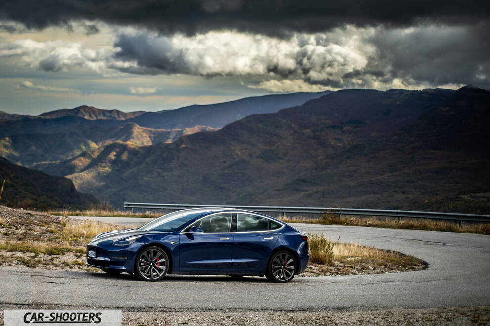 Tesla Model S Performance – side profile, dark blue against a mountain backdrop