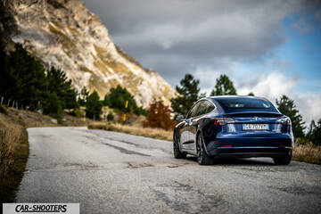 Tesla Model S Performance – rear three-quarter, blue metallic against a mountain backdrop