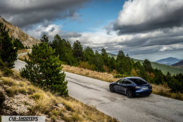 Tesla Model S Performance – rear three-quarter, blue on a winding mountain road