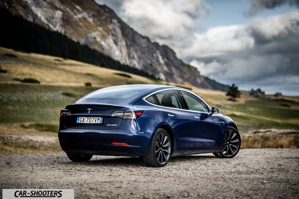 Tesla Model S Performance – rear three-quarter, blue against a mountain backdrop