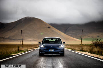 Tesla Model S Performance – front three-quarter, blue against a mountain backdrop