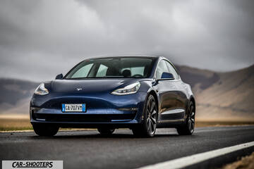 Tesla Model S Performance – front three-quarter, dark blue on a road with hills