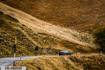 Tesla Model S Performance – rear three-quarter, dark blue on a winding hillside road