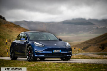 Tesla Model S Performance – front three-quarter, blue against a mountain backdrop
