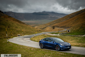 Tesla Model S Performance – front three-quarter, blue metallic on a winding mountain road
