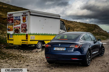 Tesla Model S Performance – rear three-quarter, dark blue against a mountain backdrop