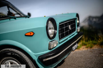 Autobianchi A112 – front three-quarter, light blue against a mountain backdrop