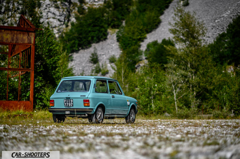 Autobianchi A112 – rear three-quarter, light blue against a mountain backdrop