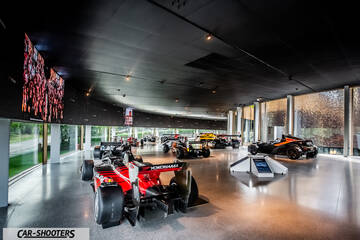 Dallara – rear three-quarter, red and black in a modern showroom