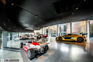 Dallara – rear three-quarter, yellow in a modern museum showroom
