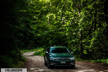 Volkswagen Passat Alltrack – front three-quarter, green on a forest road