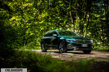 Volkswagen Passat Alltrack – front three-quarter, dark green on a forest road