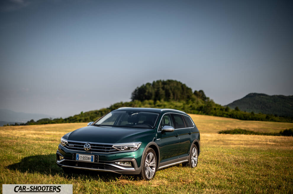 Volkswagen Passat Alltrack – front three-quarter, dark green metallic in a grassy field
