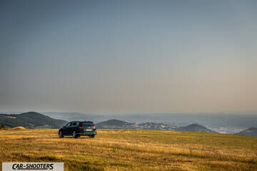 Volkswagen Passat Alltrack – rear three-quarter, dark green against a mountain backdrop