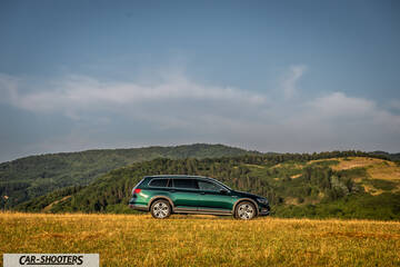 Volkswagen Passat Alltrack – side profile, green metallic against a mountain backdrop
