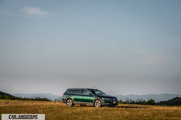 Volkswagen Passat Alltrack – front three-quarter, green against a mountain backdrop