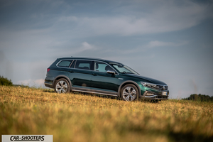 Volkswagen Passat Alltrack – front three-quarter, dark green on a grassy hill