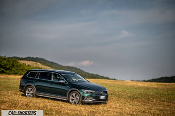 Volkswagen Passat Alltrack – front three-quarter, dark green metallic in a grassy field