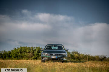 Volkswagen Passat Alltrack – front three-quarter, dark green in a grassy field