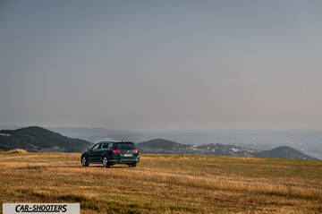 Volkswagen Passat Alltrack – rear three-quarter, dark green dark green parked on a grassy hill