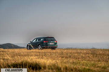 Volkswagen Passat Alltrack – rear three-quarter, dark green against a mountain backdrop