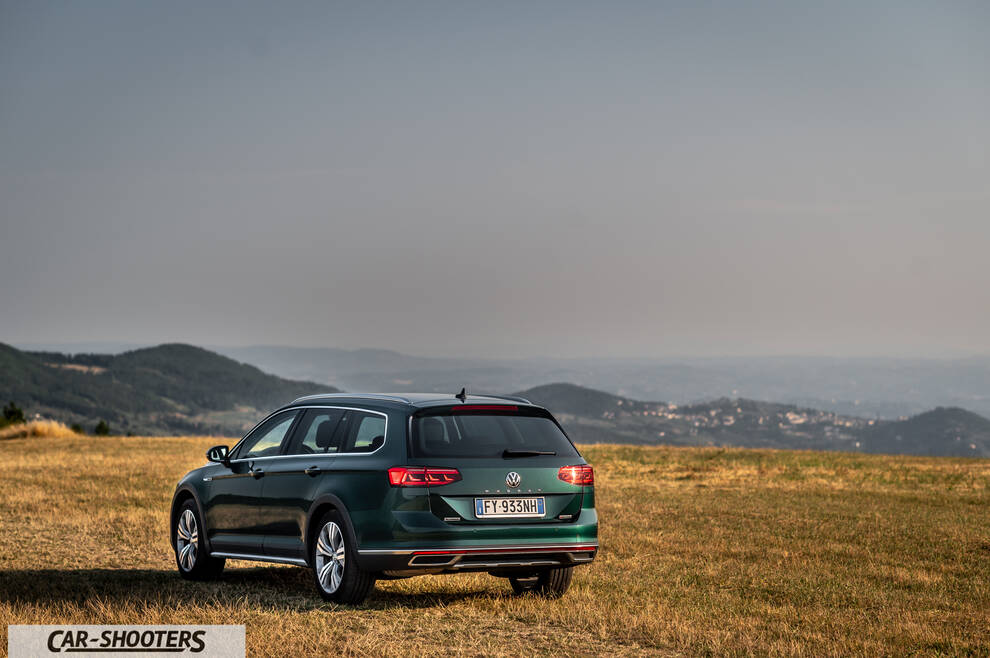 Volkswagen Passat Alltrack – rear three-quarter, dark green against a hilly backdrop