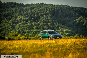 Volkswagen Passat Alltrack – front three-quarter, green against a mountain backdrop