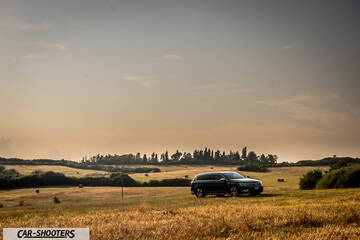 Volkswagen Passat Alltrack – front three-quarter, dark blue in a grassy field