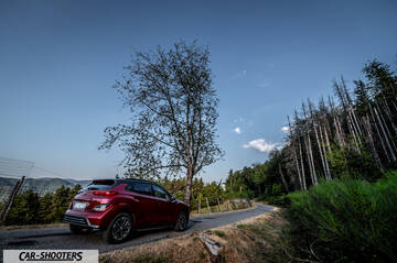 Hyundai Kona Electric 2021 – rear three-quarter, red on a country road