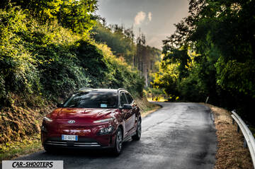 Hyundai Kona Electric 2021 – front three-quarter, dark red on a country road