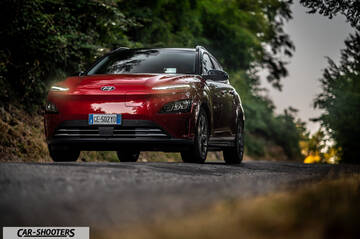 Hyundai Kona Electric 2021 – front three-quarter, red on a country road