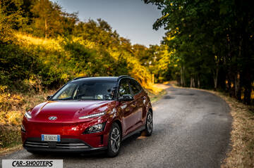 Hyundai Kona Electric 2021 – front three-quarter, red metallic on a country road