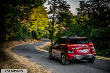 Hyundai Kona Electric 2021 – rear three-quarter, red on a country road