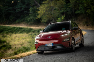 Hyundai Kona Electric 2021 – front three-quarter, red on a country road