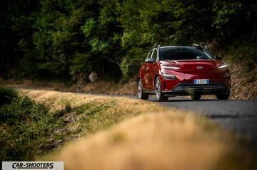 Hyundai Kona Electric 2021 – front three-quarter, red on a country road