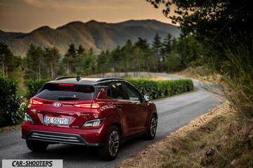 Hyundai Kona Electric 2021 – rear three-quarter, dark red on a country road