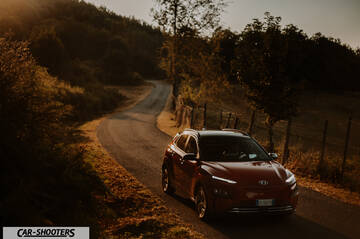 Hyundai Kona Electric 2021 – front three-quarter, red on a country road