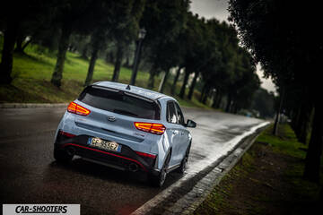 Hyundai i30N – rear three-quarter, light blue on a tree lined road