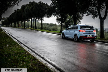 Hyundai i30N – rear three-quarter, light blue on a wet country road