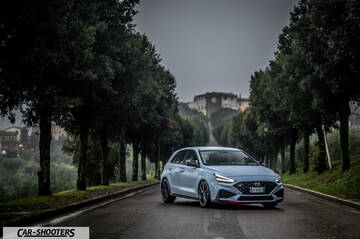 Hyundai i30N – front three-quarter, light blue on a tree lined road