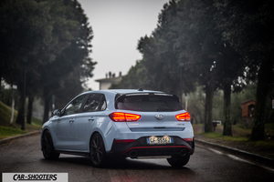 Hyundai i30N – rear three-quarter, light blue on a tree lined road