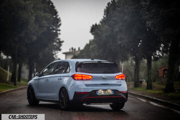 Hyundai i30N – rear three-quarter, light blue on a tree lined road